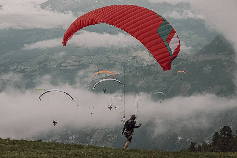 Paragleiter am Himmel und beim Start