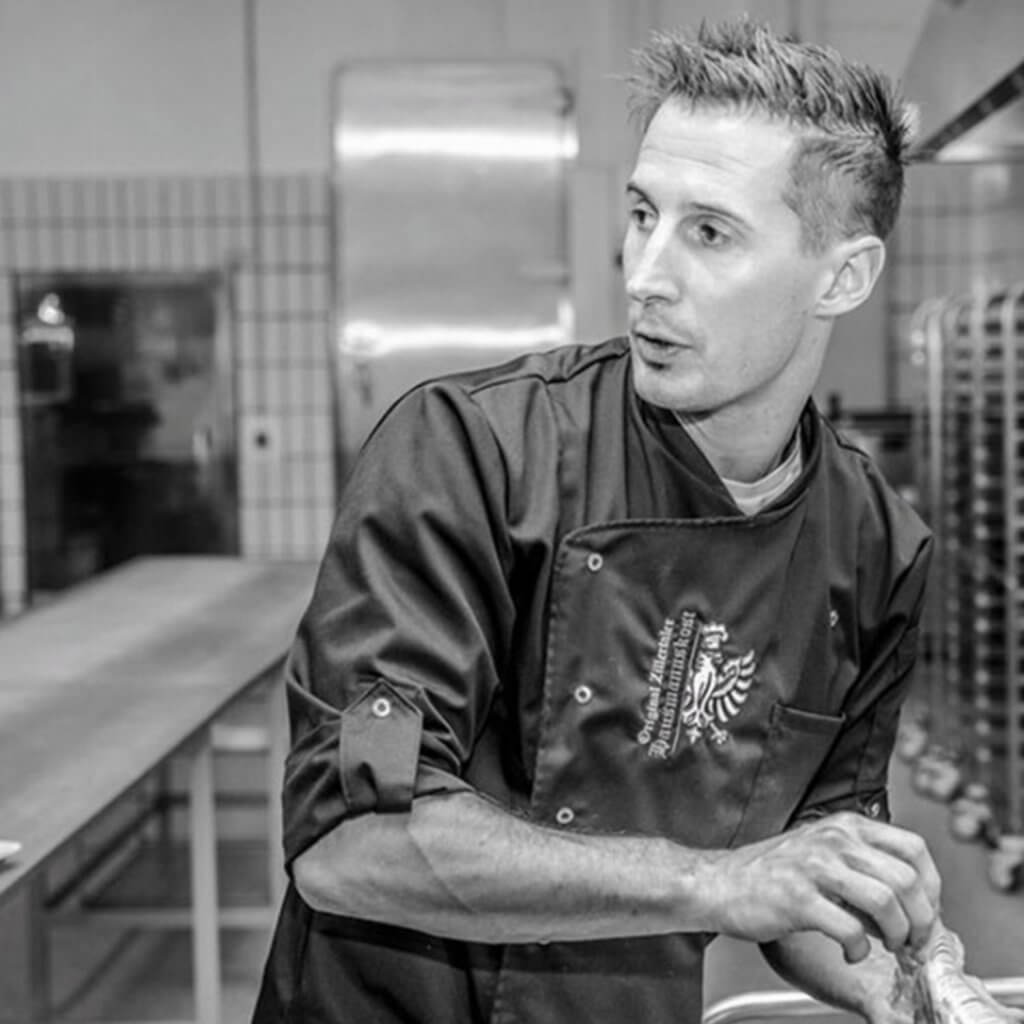 Leckere traditionelle Zillertaler Hausmannskost serviert auf rustikalem Holztisch, Hinweis auf regionale Küche und nachhaltige Nahrung